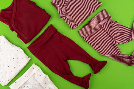 Top view of baby clothes on green backgroundの写真素材