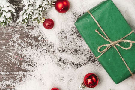 Christmas gift on wooden table powdered with snowの写真素材