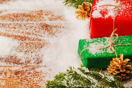 Decorated present on snowy wooden table close up