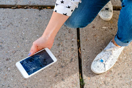 Woman just broke her smartphone on the floorの写真素材