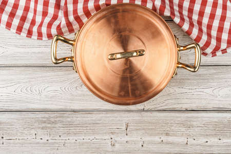 Flatlay of copper cooking pot on wooden backgroundの写真素材