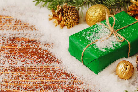 Decorated present on snowy wooden table close upの写真素材