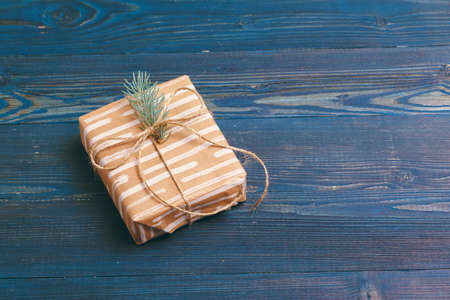 Christmas gifts with fir tree branches on wooden background