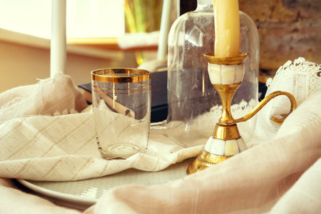 Golden candlestick and glass on the tableの写真素材