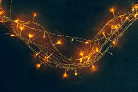 Warm light illuminated garland close up on dark backgroundの写真素材