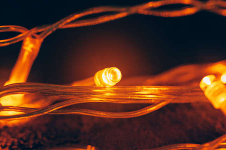 Illuminated garland close up on dark backgroundの写真素材