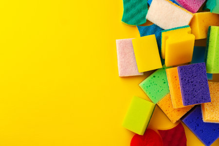 Pile of new cleaning sponges on yellow background, top viewの写真素材