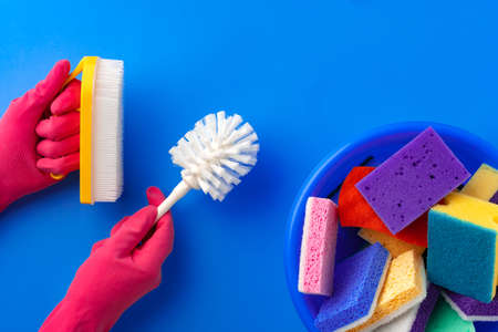 Ð¡leaning supplies with hands in rubber gloves on blue backgroundの写真素材