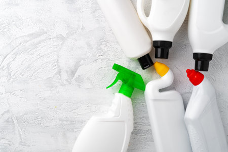 Set of different bottles of detergents top view on grey background