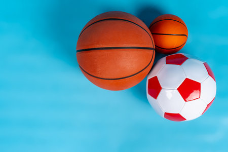 Basketball and soccer balls on a blue backgroundの写真素材