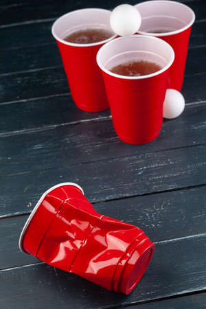 Wooden table with red cups and ball for beer pongの写真素材