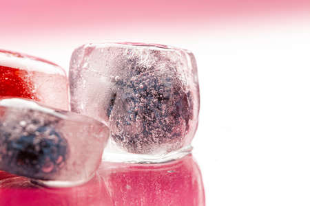 Fresh berries frozen in ice cubes for drinks