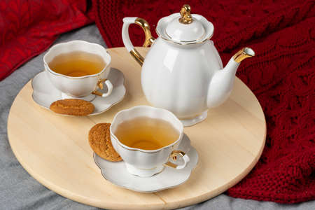 White porcelain cup of tea and oat cookies on a table