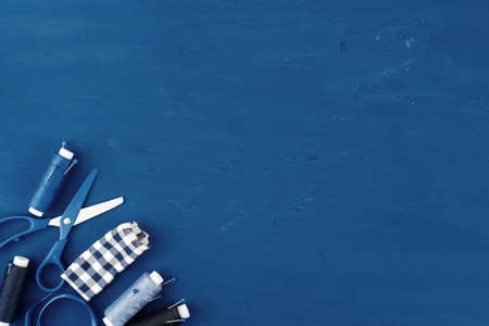 Tayloring accessories on classic blue background, top view