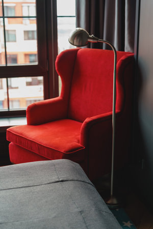 Stylish red arm chair and lamp against window in a hotel roomの写真素材