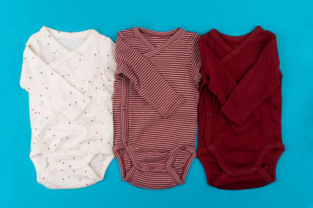 baby clothes on blue background top view