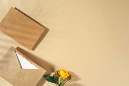 Craft paper envelope with yellow roses on beige backgroundの写真素材
