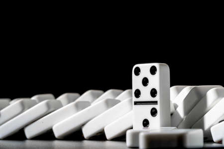 Dominoes standing in a row on black backgroundの写真素材