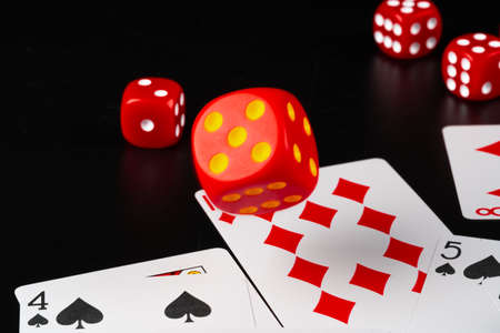 Dice and cards scattered on table close up