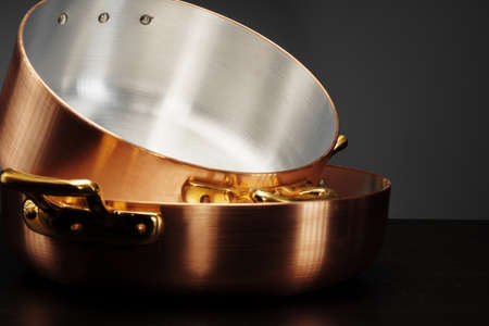 New copper cooking ware over dark backgroundの写真素材