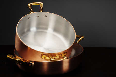 New copper cooking ware over dark backgroundの写真素材