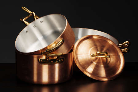 Set of copper cookware over dark background