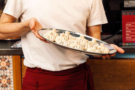Georgian khinkali tray in hands close upの写真素材