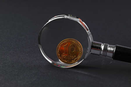 Ukrainian money coin through magnifying glass close up