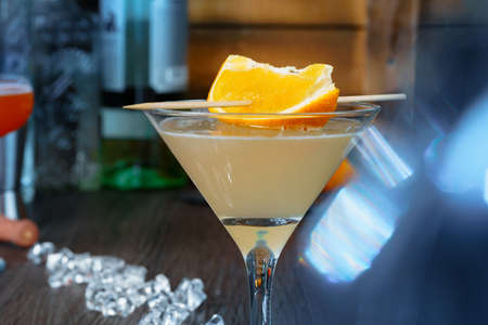 Alcoholic coktail served with orange slice close up