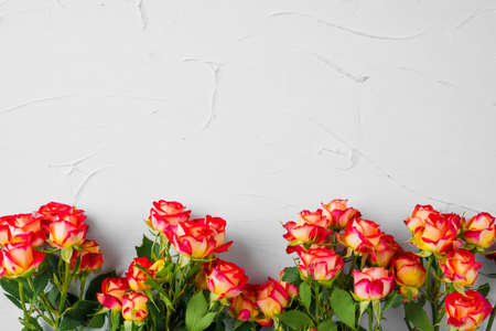 Small roses bouquet on light grey textured background with copy space