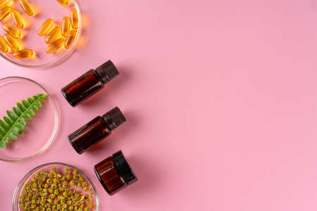 Health, skin care and beauty concept. Cosmetic containers on pink background with plant leaves