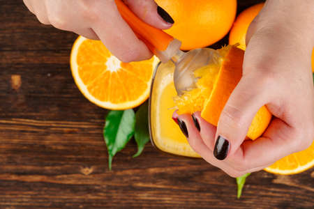 Woman hand squeezes orange juice close upの写真素材