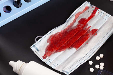 Stained medical protective mask with test tubes. Coronavirus diagnostic and treatment analysis...