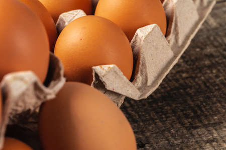 Chicken eggs in box on wooden table.