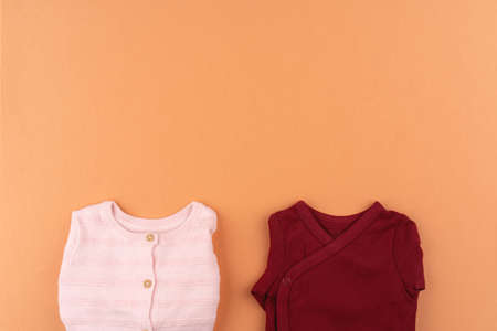 Clothes of baby girl on orange background top viewの写真素材