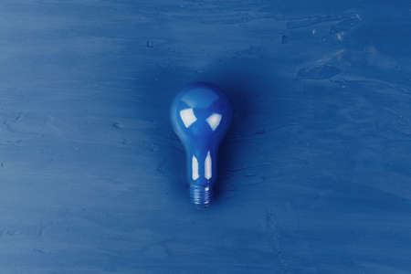 Painted lightbulb on classic blue background, top viewの写真素材
