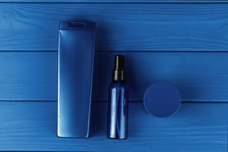 Men cosmetic bottles on classic blue background, top view