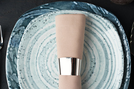 Table setting. Plates with abstract pattern on black table