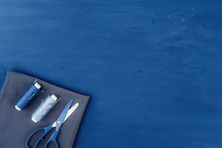 Tayloring accessories on classic blue background, top view