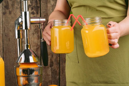 Woman using orange juicer apparatus at home