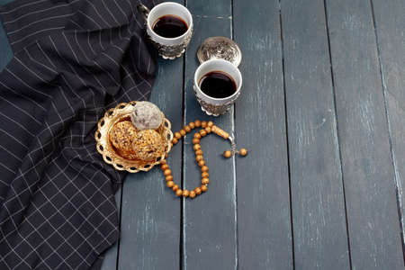 Nut balls dessert served with coffee on dark wooden table, top view