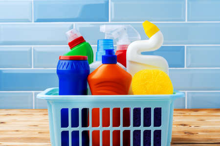 Household detergents and cleaning tools against blue tile backgroundの写真素材
