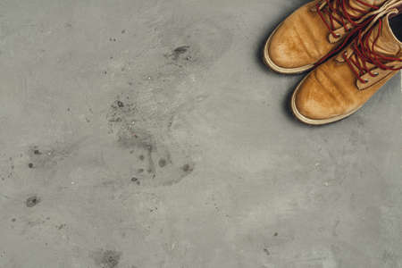 Hiking boots with travel accessories on grunge background