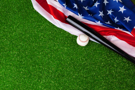 Baseball bat and ball with american flag on grassの写真素材