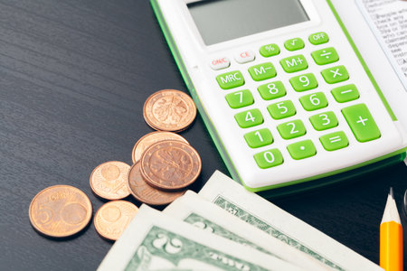 avings, finances, economy and home concept - close up of calculator counting money and making notes...