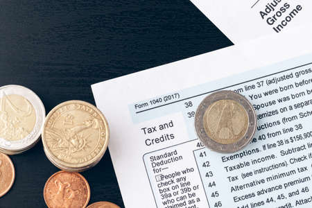 The close-up of accounting documents with money coinsの写真素材