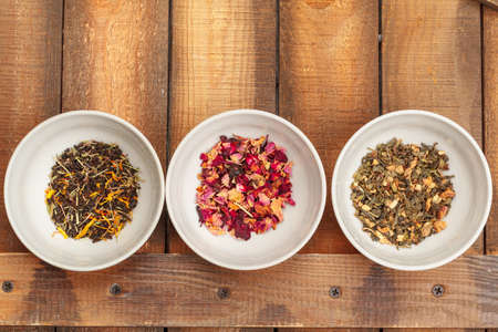 Aromatic dry tea in bowls on wooden backgroundの写真素材
