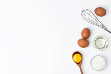 Fresh eggs with whisk isolated on white backgroundの写真素材