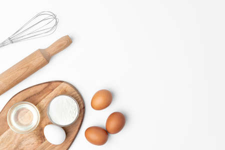 Metal whisk and eggs for cooking isolated on white