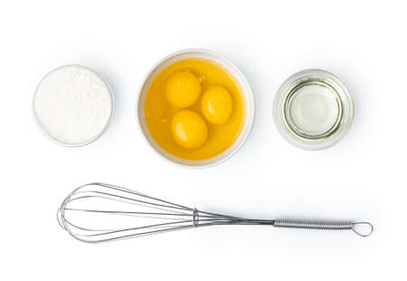 Metal whisk and eggs for cooking isolated on white background